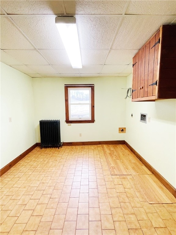 interior space with light tile flooring, radiator heating unit, and a paneled ceiling