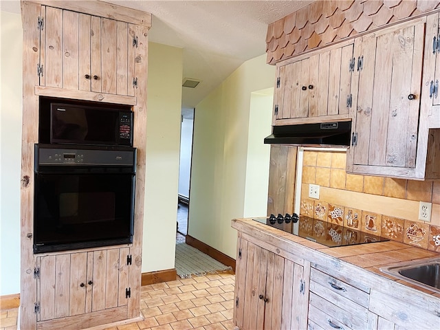 kitchen with sink, backsplash, black appliances, and light tile floors