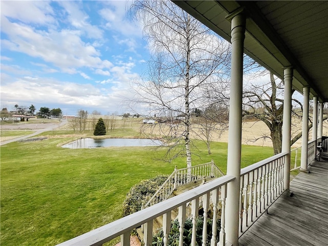 deck featuring a water view and a lawn