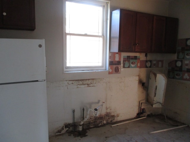 kitchen with white fridge and dark brown cabinetry