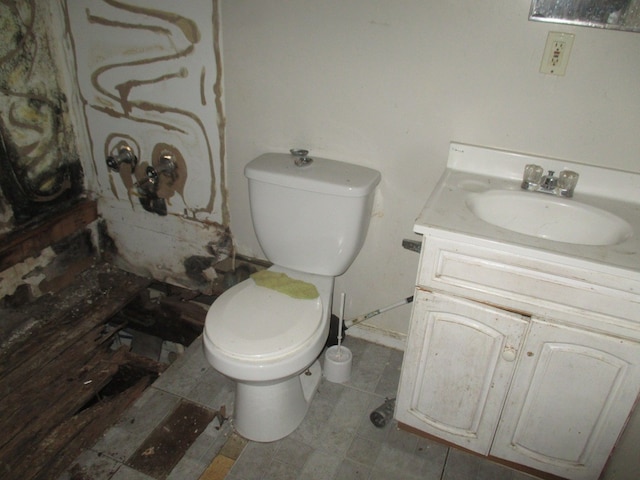 bathroom featuring toilet, tile floors, and vanity