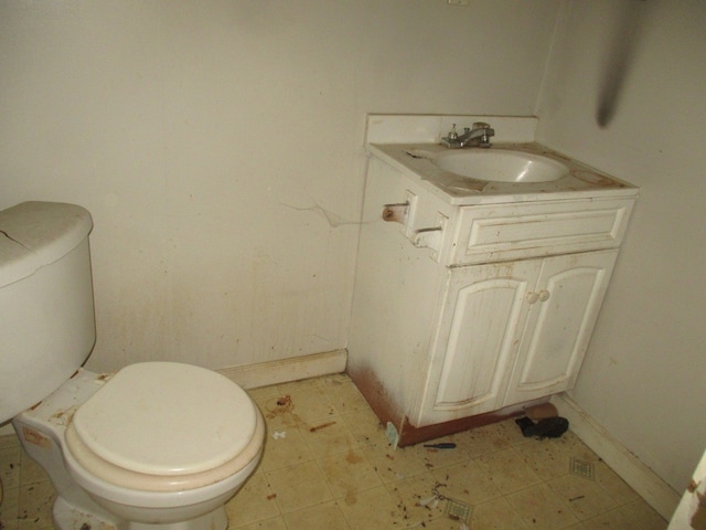 bathroom with vanity, tile floors, and toilet