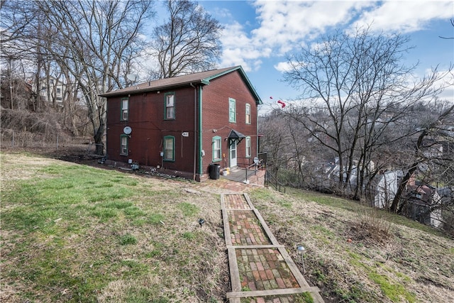 view of side of property featuring central AC unit and a yard