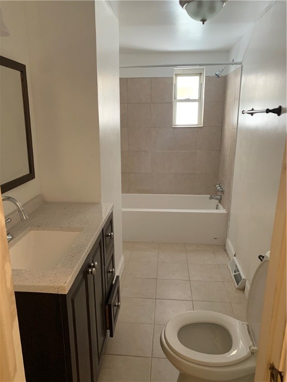 full bathroom featuring tile flooring, oversized vanity, toilet, and tiled shower / bath combo