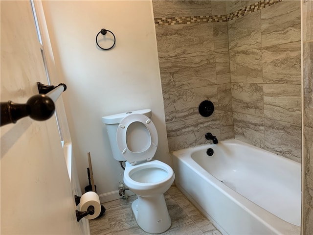 bathroom featuring tile floors, tiled shower / bath combo, and toilet