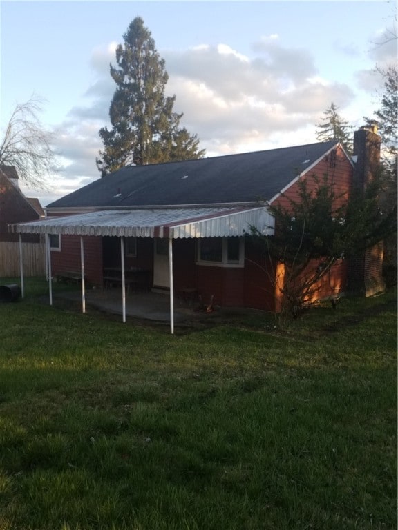 rear view of house featuring a lawn