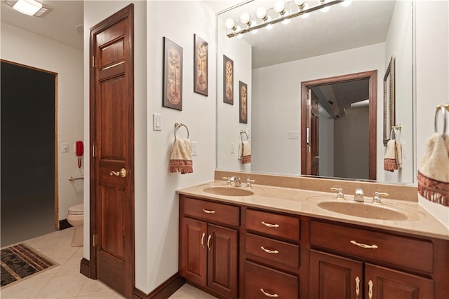 bathroom featuring double vanity, tile patterned floors, and toilet