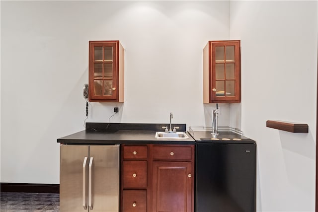 bar featuring wood-type flooring, fridge, and sink