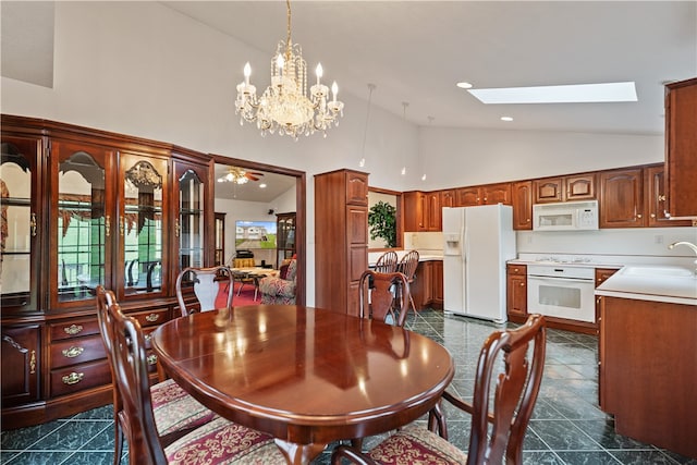 dining area with a skylight, sink, dark tile patterned floors, and plenty of natural light