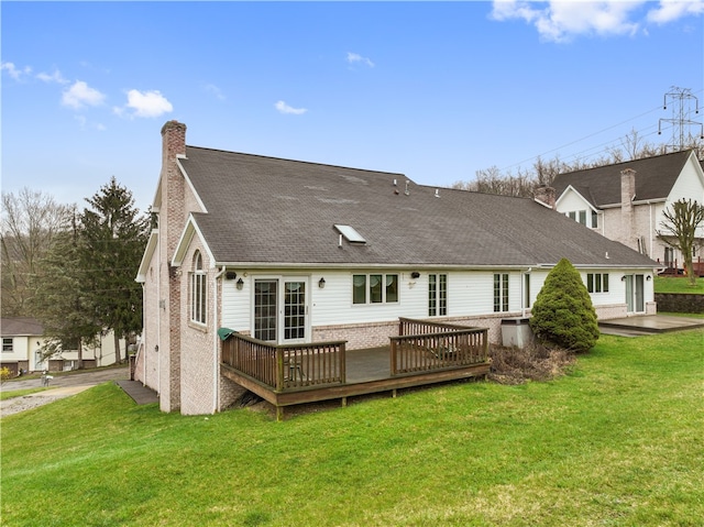 rear view of property with a wooden deck and a lawn