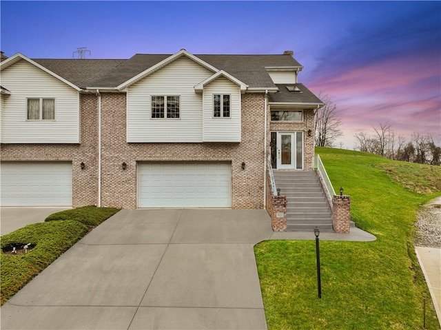 view of front of home with a garage and a yard