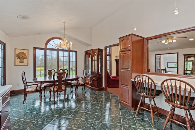 dining area featuring dark tile patterned floors, vaulted ceiling, and ceiling fan with notable chandelier