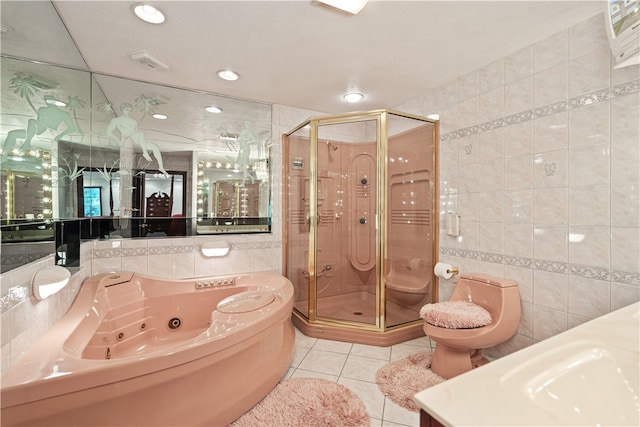 full bathroom featuring toilet, vanity, tile walls, tile patterned floors, and separate shower and tub