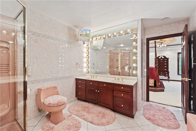 bathroom featuring tile patterned flooring, tile walls, vanity, and a textured ceiling