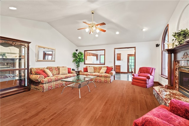 living room featuring a premium fireplace, ceiling fan, hardwood / wood-style flooring, and lofted ceiling