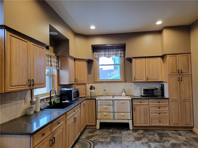 kitchen with backsplash, dark tile flooring, and plenty of natural light