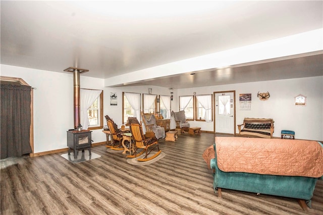 bedroom with a wood stove and hardwood / wood-style flooring