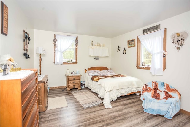 bedroom with dark wood-type flooring and multiple windows