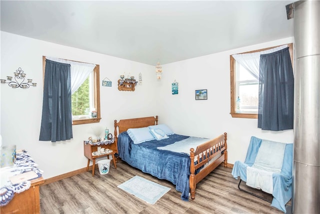 bedroom featuring a wood stove and light wood-type flooring