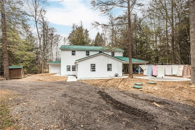 back of property featuring an outdoor structure