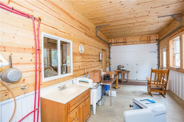 interior space with wooden walls, vanity with extensive cabinet space, and wood ceiling