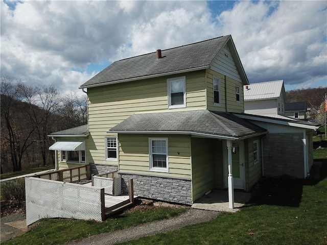 rear view of property with a deck and a yard