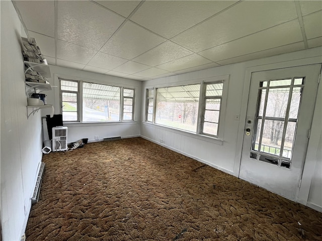 carpeted spare room with a paneled ceiling and a baseboard heating unit