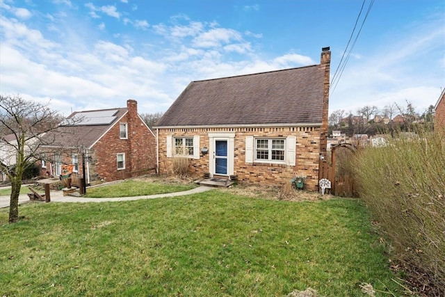 view of front of home with a front lawn and solar panels