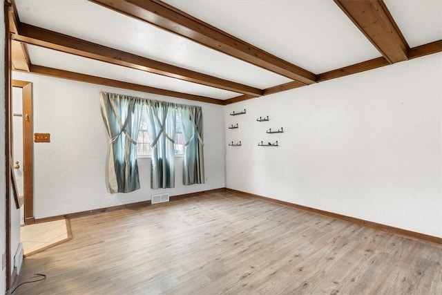 unfurnished room with beam ceiling and light wood-type flooring