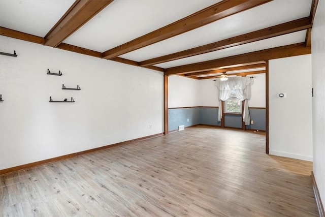 spare room with ceiling fan, beam ceiling, and light wood-type flooring