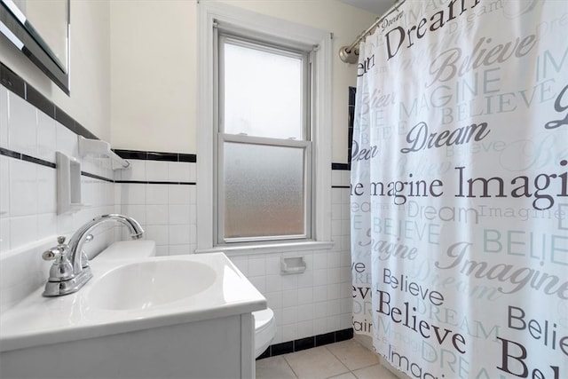 bathroom featuring tile walls, tile floors, a wealth of natural light, and vanity