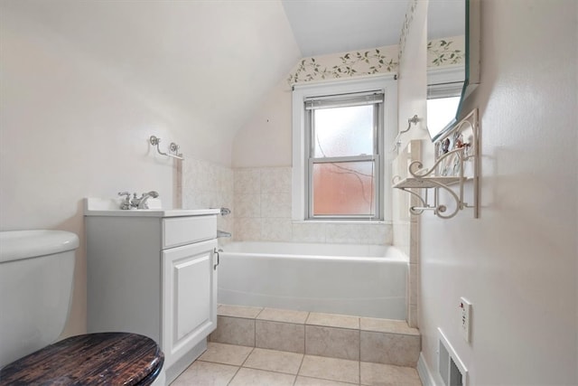 bathroom with tile floors, toilet, vanity, and vaulted ceiling