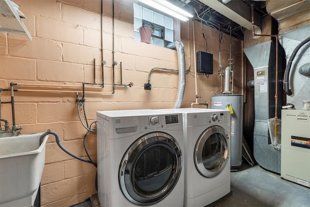 clothes washing area featuring sink, washer and clothes dryer, gas water heater, and washer hookup