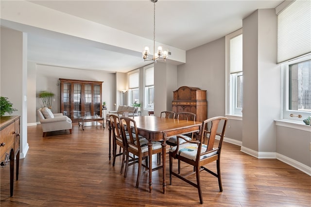 dining area with dark hardwood / wood-style flooring, a notable chandelier, and a wealth of natural light