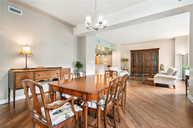 dining area featuring an inviting chandelier and dark hardwood / wood-style flooring