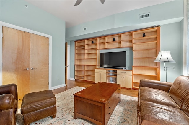 living room with ceiling fan and light hardwood / wood-style flooring