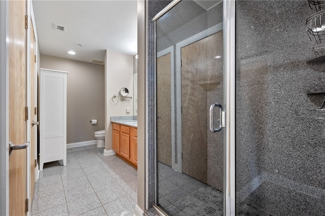 bathroom with tile flooring, toilet, vanity, and a shower with shower door