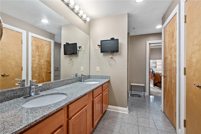 bathroom featuring dual sinks, oversized vanity, and tile flooring