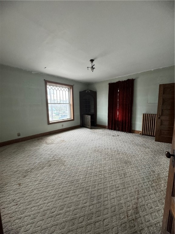 interior space with a tiled fireplace and radiator heating unit