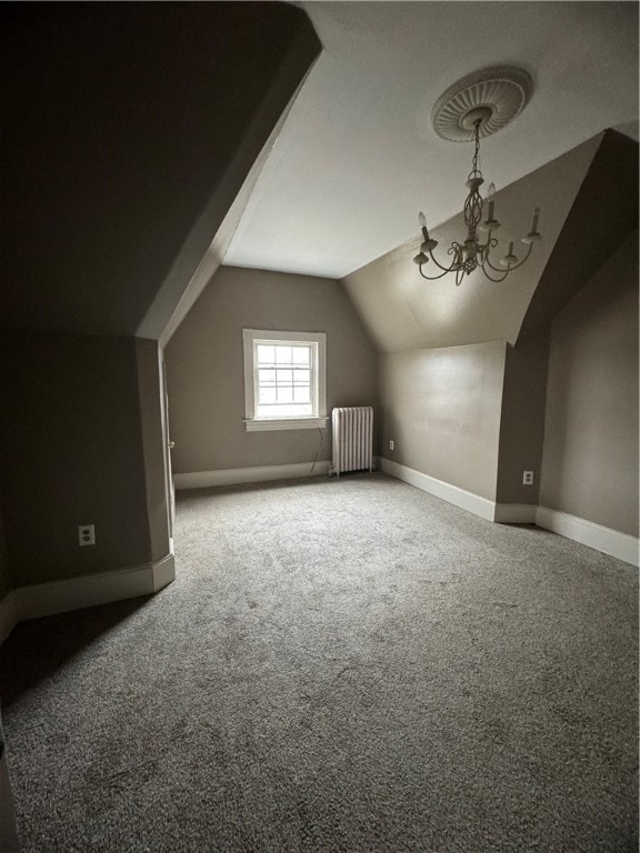 additional living space with lofted ceiling, radiator, a chandelier, and carpet flooring