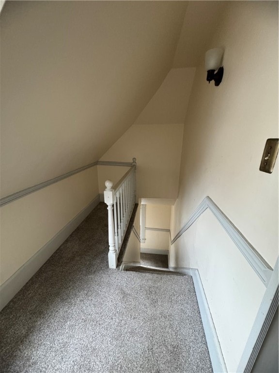 interior space featuring carpet floors and vaulted ceiling