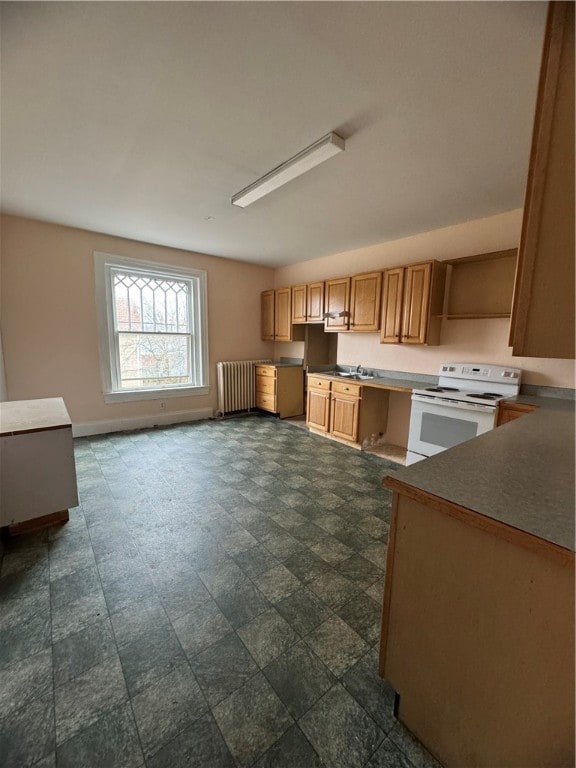 kitchen with sink, dark tile floors, radiator, and white electric range