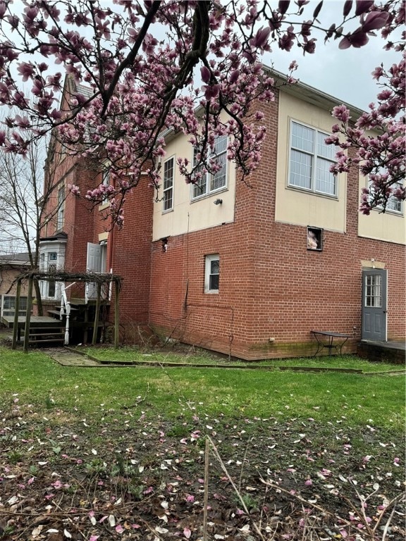 view of home's exterior with a deck and a lawn