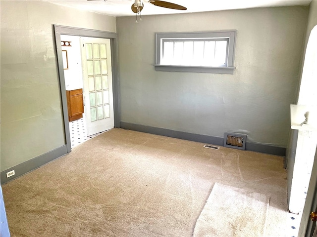 carpeted spare room featuring ceiling fan