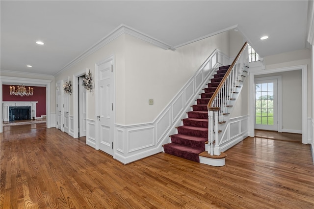 interior space with a notable chandelier, ornamental molding, and hardwood / wood-style floors