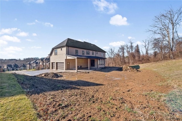 back of house featuring a yard and a garage