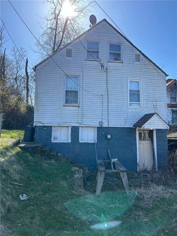 rear view of house featuring a lawn