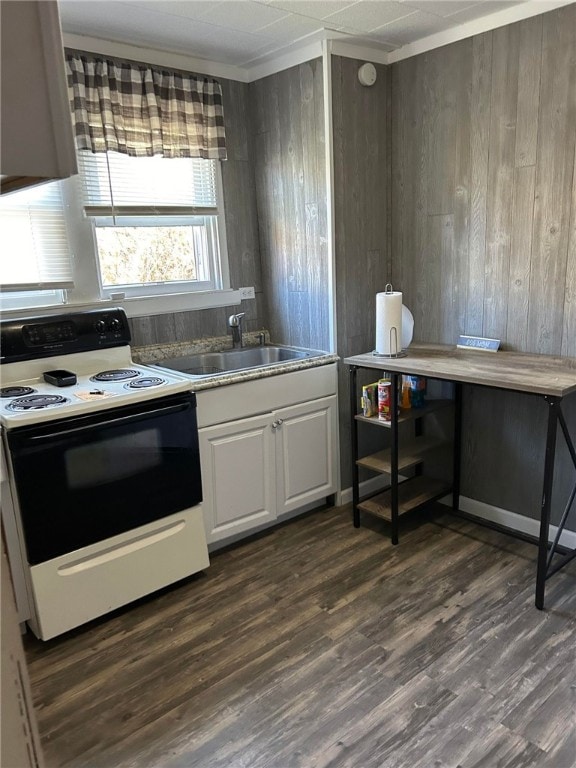 kitchen featuring dark hardwood / wood-style flooring, wood walls, white cabinetry, sink, and white range with electric cooktop