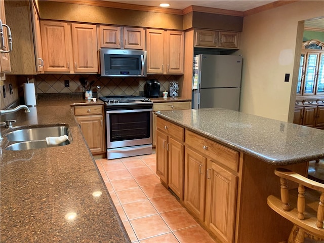 kitchen featuring sink, light tile floors, dark stone counters, appliances with stainless steel finishes, and tasteful backsplash