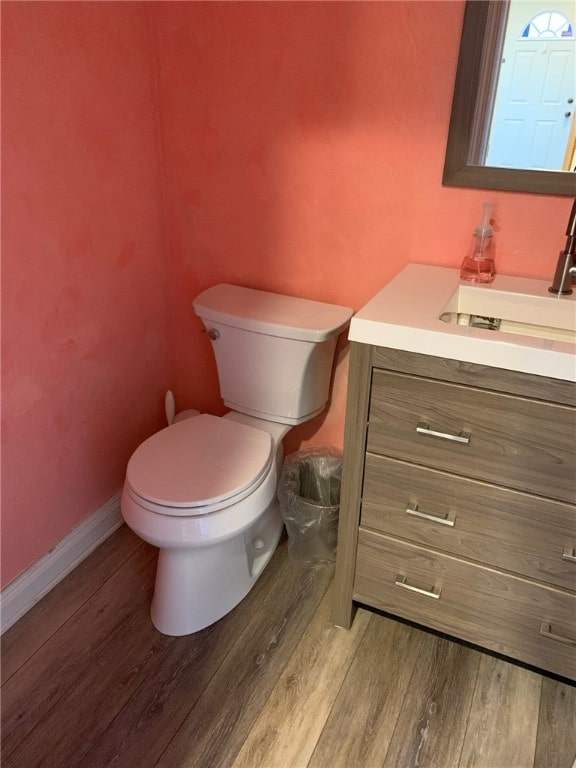 bathroom featuring toilet, vanity, and hardwood / wood-style flooring